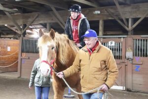 Martin smiles while riding a horse