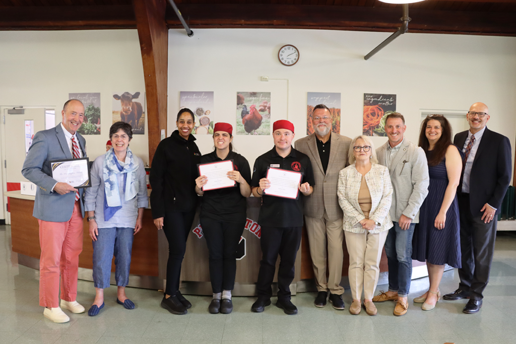 Eden participants smile with their parents and Eden staff members