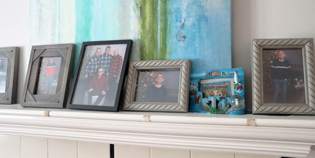 The living room mantle displays photos of the housemates, including from a trip to Boston