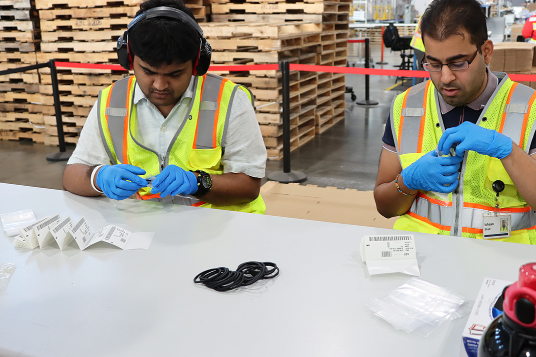 Two men assemble products at a warehouse