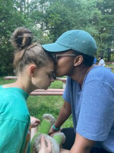 An Eden staff member kisses an Eden student on the forehead at camp.